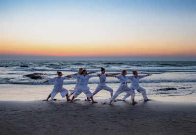 6 kvinner i hvitt i kriger 2 posisjon på strand i Goa