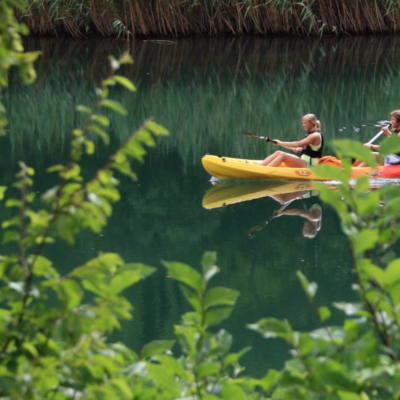 <p>Damer som padler gul kajakk i grønt, speilblankt vann i Kroatia</p>