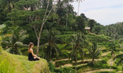 Kvinne som mediterer med utsikt over rismarkene i Ubud på Bali