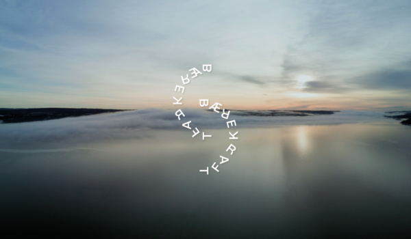 Bilde utover Oslofjorden på Nesoddtangen. Himmelen har lette skyer og speiler seg i vannet. Det er skumring. På bildet står ordet 'bærekraft' to ganger som et dekorativt element. 