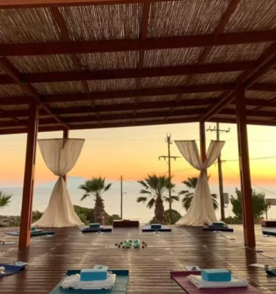 Oversiktsbilde av yogasal i solnedgang på Karpathos. Puter, matter og yogautstyr dandert i sirkel for yogareise